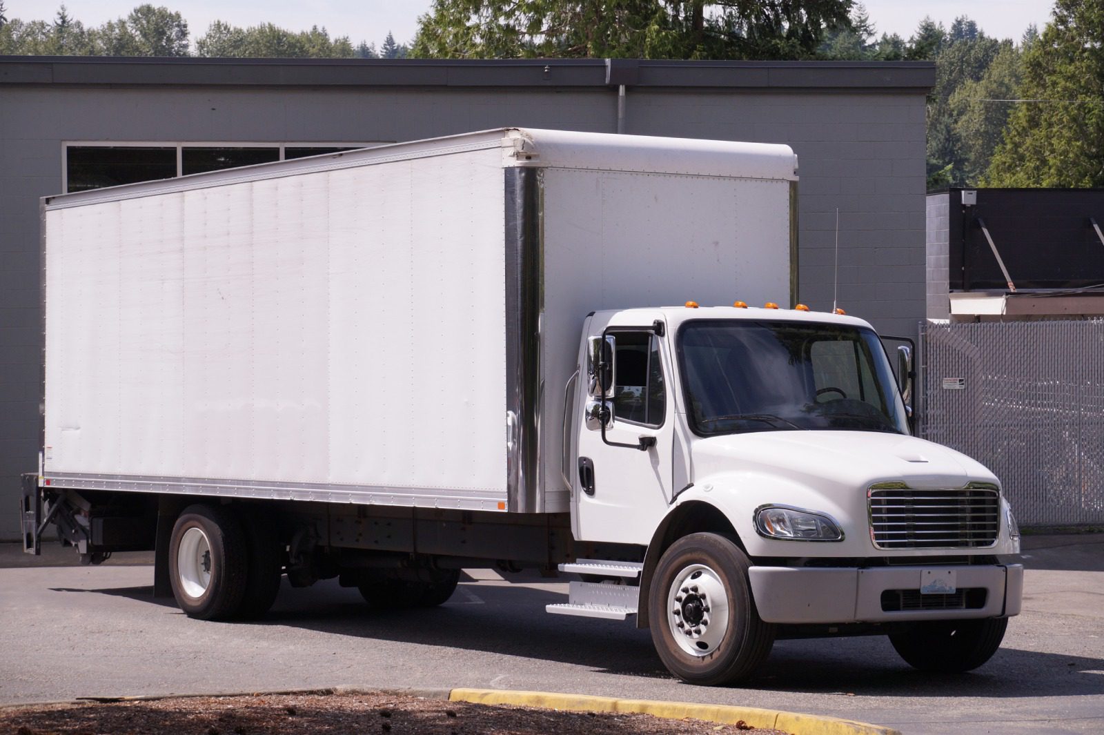 A white truck parked in front of a building.